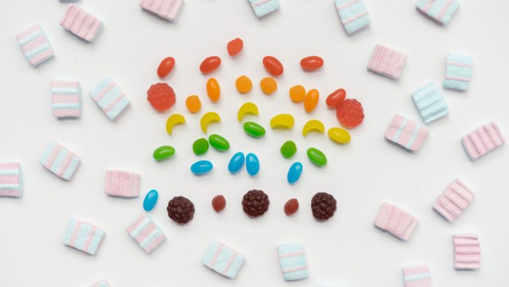 Vibrant arrangement of assorted candies on a white surface, showcasing playful colors.